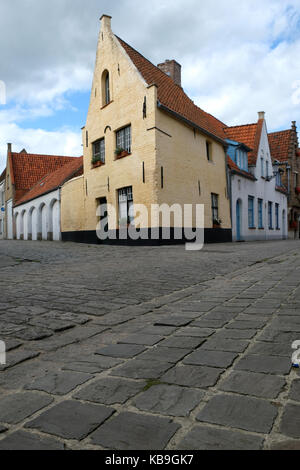 Straßenszene in Brügge, Belgien mit gelben Haus und Pflastersteine Pflastersteine Stockfoto