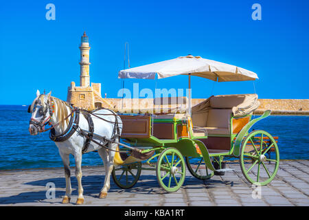 Blick auf den alten Hafen von Chania mit Pferdekutschen und Leuchtturm, Kreta, Griechenland. Stockfoto