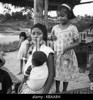 Eine Mutter mit Kindern, Stand auf einer Straße in der Stadt Purto Napo, Ecuador 1960er Jahre. Eine Mutter mit ihren Kindern in den Straßen der Stadt von Puerto Napo, Ecuador 1960. Stockfoto