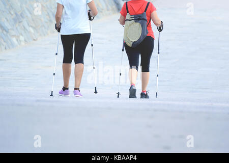 Zwei ältere aktive Frauen üben einige Nordic Walking in der Stadt. Städtische Aktivität Konzept und leere Raum für Editor's Text. Stockfoto