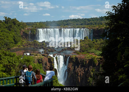 Touristen auf Aussichtsplattform auf der brasilianischen Seite der Iguazu-Fälle, Blick auf die argentinische Seite, Südamerika Stockfoto