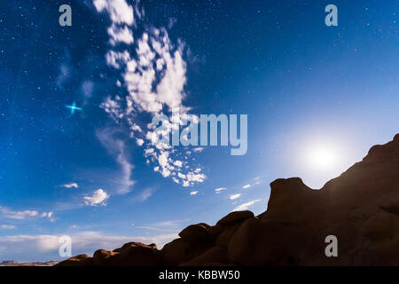Nachthimmel mit Vollmond, oder Mondaufgang, Goblin Valley State Park in Utah, Wolken, Sterne und Schluchten Silhouetten in der Wildnis der Natur Stockfoto