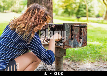 Junge Frau Reinigung berühren Grill Picknick Grill im Freien Sommer Park closeup Stockfoto