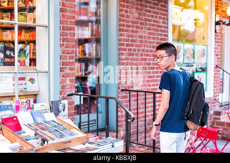 Washington DC, USA - August 4, 2017: Zurück Nahaufnahme von jungen asiatischen Mann student boy Auschecken gebrauchte Bücher an unabhängige Buchhandlung in Georgetown neighb Stockfoto