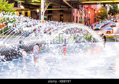 Washington DC, USA - August 4, 2017: Junge jungen Kindern beim Spielen im Brunnen in Georgetown Waterfront Park in den Abend mit Wasser spritzen Stockfoto