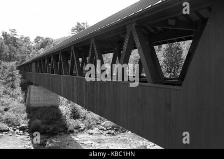 Eine alte New-Hampshire Brücke überquert eine beschäftigte Bach im Wald. Stockfoto