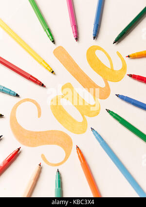 Bild von Hand geschrieben Kalligraphie Schrift "Verkauf" mit orangefarbenen Markierungen auf weißem Papier Stockfoto