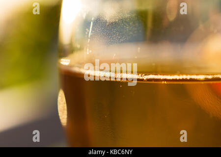 Nahaufnahme von Glas mit köstlichen griechischen Retsina Wein und kleine Bläschen bei Sonnenuntergang Stockfoto