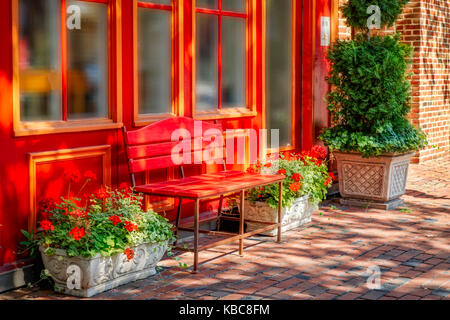 Eine bunte Sitzbank und Blumen auf der gepflasterten Gehsteigen im nördlichen Virginia. Stockfoto