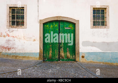 Alte garage grüne Tür und zwei Fenstern Stockfoto