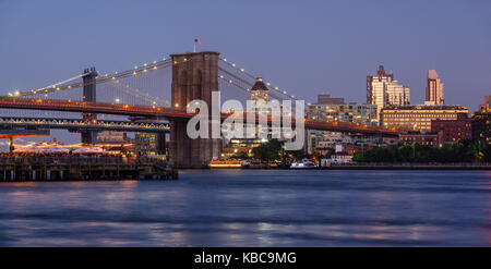 Panoramablick von Brooklyn Riverfront mit der Brooklyn Bridge bei Dämmerung, die Manhattan Bridge und Brooklyn Bridge Park. Brooklyn, New York City Stockfoto