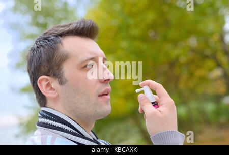 Mann Spritzen mit nasenspray im Herbst Stockfoto