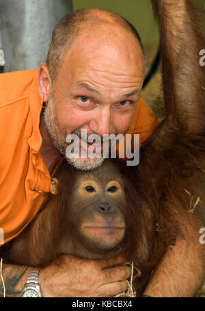 Jeremy Keeling, co Gründer von Monkey World in Dorset, mit einem jungen Orang utang, Stockfoto