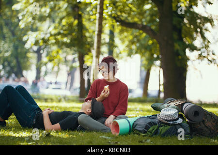 Paar jugendliche Touristen mit Rucksäcken haben Rest in der Stadt park Stockfoto