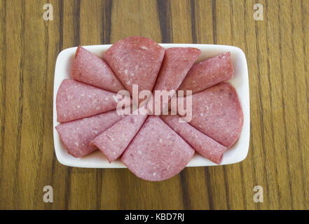 Salami in Scheiben geschnitten auf Schneidebrett getönt Stockfoto