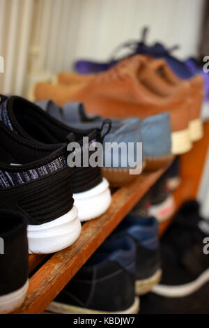 Schuhe auf hölzernen Schuhschrank. Close up Seitenansicht Bild vertikal. Stockfoto