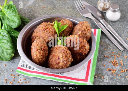 Frikadellen mit Buchweizen in einer Metallschüssel über einem grauen Abstrakt Hintergrund. Gesunde Ernährung. Gesund essen Konzept Stockfoto