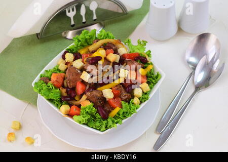 Warmer Salat mit Huhn Leber, Bohnen, Tomaten, Paprika, Croutons und Balsamico Dressing Stockfoto