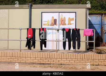 Bournemouth September 2017 - Wetsuits hängen zum Trocknen im Surf Equiptment Shop Boscombe ab Stockfoto