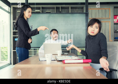 Gruppe von asiatischen Geschäft Leute an Geschäftsfrau und Kollegen die Schuld für Fehler, schlechte Arbeitsergebnisse in Business Meeting Raum. Stockfoto