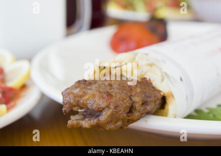 Türkisch und Arabisch traditionellen Ramadan Adana kebab Roll Wrap mit Joghurt Auberginen Salat servieren Stockfoto