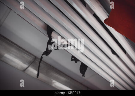 Low Angle View von Schwarzen Rucksack Klammern Fallen durch Gepäckträger in Zug Stockfoto