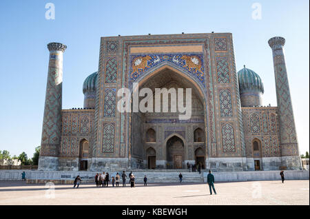 SAMARKAND, Usbekistan - Oktober 15, 2016: Leute, Touristen und Einheimischen sind auf dem Hintergrund der Schrein Sher-Dor in Registan Platz fotografiert. Stockfoto