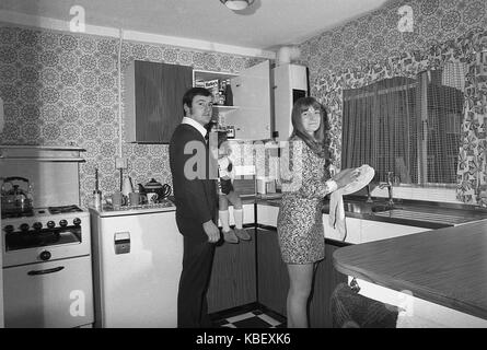 1972, historische, Mann und Frau mit Kind in der Küche ihrer vor kurzem renoviert Rat flach, Baildon Street, Deptford, London, SE8, England, UK. Stockfoto