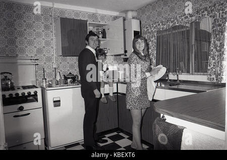 1972, historische, Mann und Frau mit Kind in der Küche ihrer vor kurzem renoviert Rat flach, Baildon Street, Deptford, London, SE8, England, UK. Stockfoto