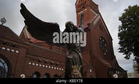 Statue des Erzengels Michael, vor der Heiligen Simon und Helena Kirche (auch der roten Kirche bekannt), in Minsk, Belarus Stockfoto