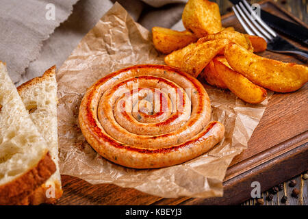 Spirale Würstchen gegrillt. mit goldenen knusprig Leckere Pommes Frites. Schnell Essen im Restaurant. Lecker gebratene Spirale Würstchen. Gegrillte Würstchen aus Stockfoto