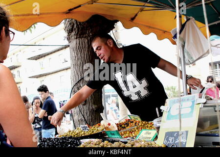 Mann mit Oliven, um Kunden an ein Open-air-Markt im Süden Frankreichs Stockfoto