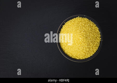 Essen Konzept organischen Couscous in Schüssel auf schiefer Platte mit Kopie Raum Stockfoto