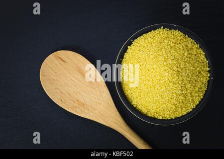 Essen Konzept organischen Couscous in Schüssel auf schiefer Platte mit Kopie Raum Stockfoto