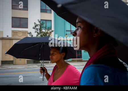 West Palm Beach, Florida, USA. 29 Sep, 2017. Kimberly Winter (links) und Naomi Smith warten auf Ihren Bus im Regen auf North Quadrille Boulevard am Freitag, 29.09.2017, West Palm Beach, Florida. Credit: Calla Kessler/der Palm Beach Post/ZUMA Draht/Alamy leben Nachrichten Stockfoto