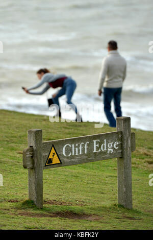 Birling Gap, East Sussex. 30. September 2017. Die Besucher der berühmten Sieben Schwestern Kreidefelsen, Risiken einzugehen, um selfies am Rande der bröckelnden Klippe Rand nur Stunden, bevor Schritte zum Strand durch die Erosion geschlossen sind. Die Schritte werden auf den 1. Oktober geschlossen werden, Jahre früher als erwartet, und zwar wegen der Zunahme Cliff fällt. © Peter Cripps/Alamy leben Nachrichten Stockfoto