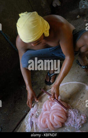 Man aufpumpen Schweine Därme, Angeles, Central Luzon, Philippinen. Stockfoto