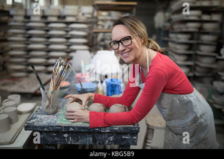 Portrait von Frau Kontrolle Becher an der Arbeitsplatte in der Töpferei Stockfoto