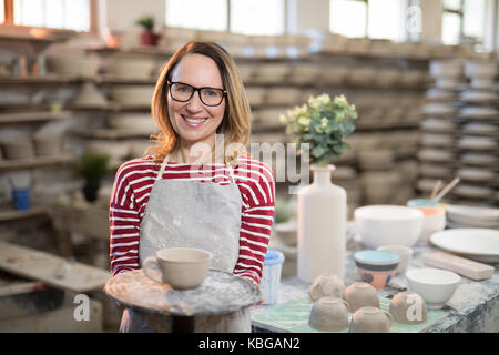 Portrait von weiblichen Potter holding Schale in der Töpferei Stockfoto