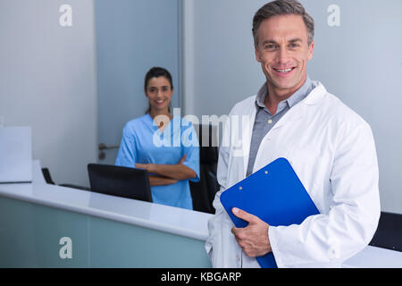 Portrait von lächelnden Ärzte gegen Wand an der Medizinischen Klinik stehend Stockfoto