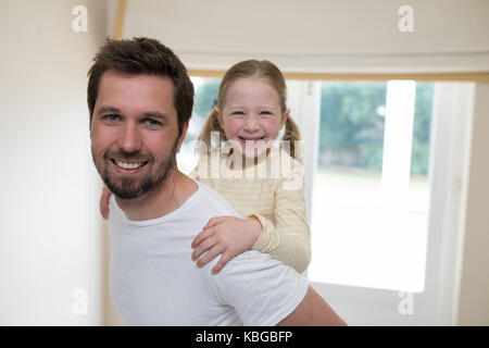 Junges Mädchen fährt Huckepack auf ihre Väter Schultern Stockfoto