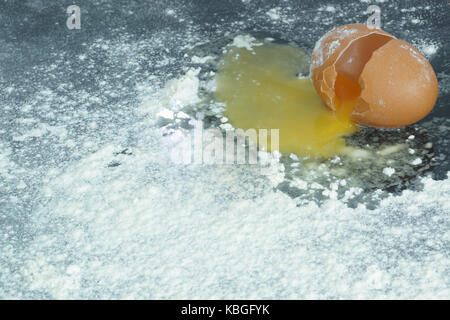 Ein kaputtes Ei auf ein Mehl bedeckten Oberfläche Stockfoto