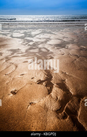 Die glitzernden Sand Bäche bilden abstrakte Muster am Strand. Stockfoto