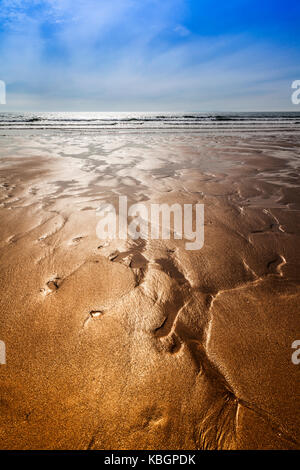 Die glitzernden Sand Bäche bilden abstrakte Muster am Strand. Stockfoto