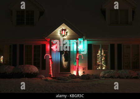 Saisonale Haus im Freien Dekoration. Hintergrund mit Haus Eingang und Vorgarten, abgedeckt durch frischen Schnee dekoriert für Weihnachten und das neue Jahr fei Stockfoto