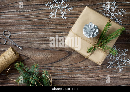 Weihnachten Hintergrund mit Geschenkverpackung. Weihnachtsgeschenke in handgefertigten Boxen auf einem Holztisch. kopieren. Stockfoto