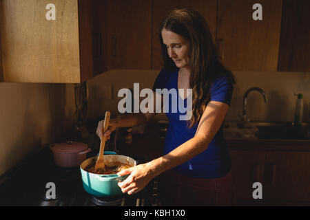 Ältere Frau, die Zubereitung von Speisen in der Küche zu Hause. Stockfoto