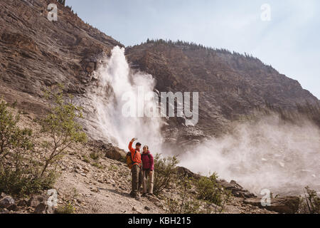 Wanderer Paar unter einem Wasserfall in der Nähe von selfie Stockfoto