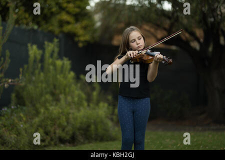 Mädchen spielen Geige im Park Stockfoto