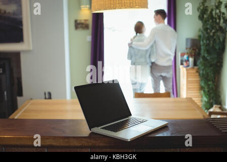 Blick auf Laptop auf hölzernen Tisch während der paar in Hintergrund Stockfoto